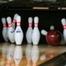 Bowling Kugel stürzt Kegel um